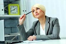 woman holding a pen against her temple while looking up and thinking about something