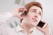 man calling with two cellphones against both of his ears